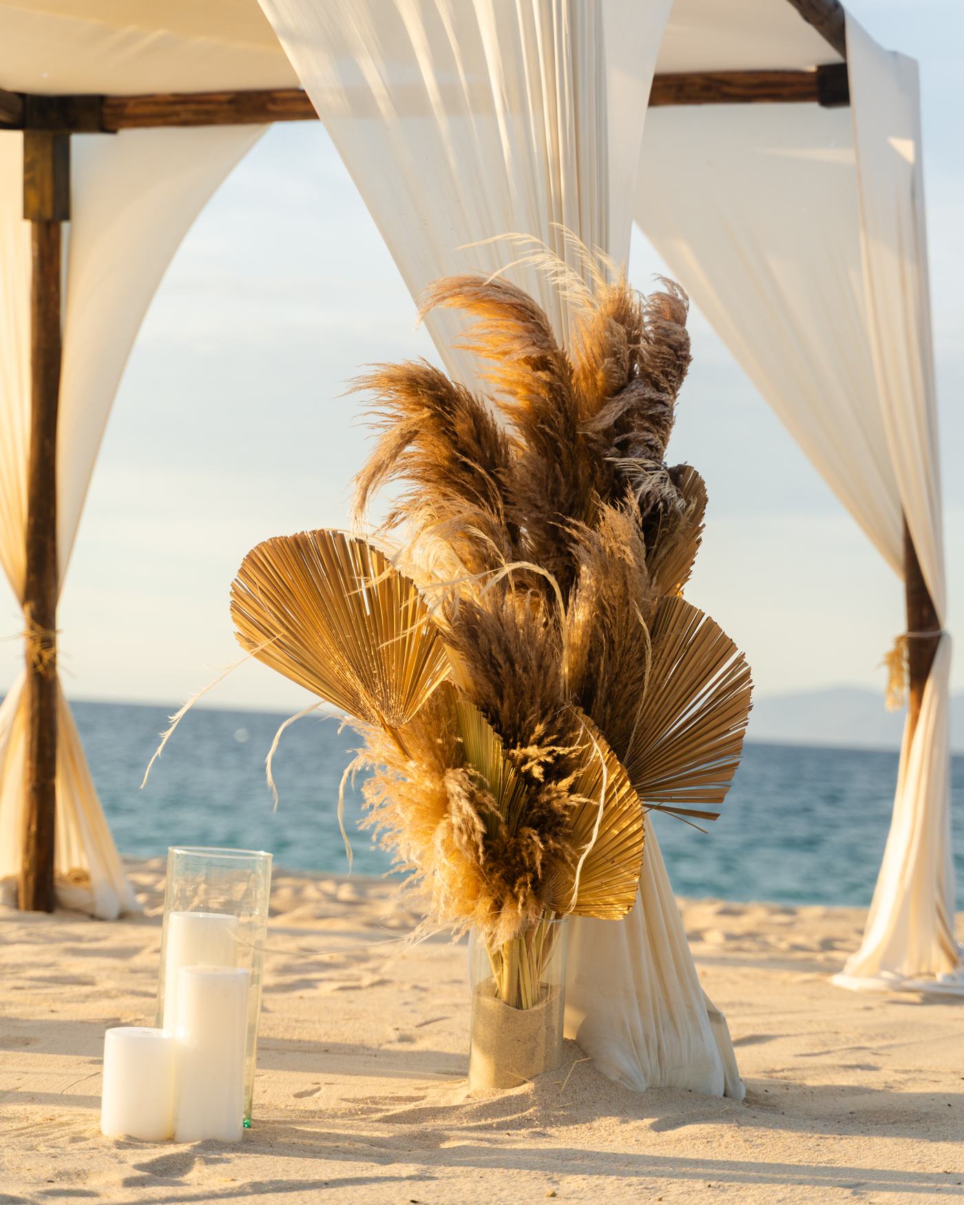 Decoración de pampas y palma seca junto a la carpa de ceremonia